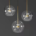 Three Transparent Glass Globe Pendant Lights With Golden Metal Rod And Modern Design