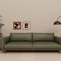 Green Leather Three-Seat Sofa with Wooden Legs Black Floor Lamp Wall Art and Potted Plant