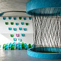 Indoor Art Installation Featuring Blue Circular Structure Black Woven Lines Colorful Chairs And Wall Decorations