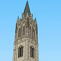 Gothic Style Stone Tower With Pointed Spire Windows And Architectural Details Against Blue Sky