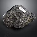 Natural Black Wood Stone With Golden Spots And Label On Dark Background