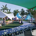 Camping Site With Green White Tents Palm Trees Lawn Decorative Lights Tables Chairs