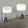 Two Modern Table Lamps With Transparent Crystal Shade And Black Base Illuminated On Table