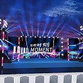 Eye Catching Stage Design With Colorful Lights Large Screens And MOMENT Text Elements