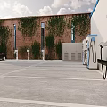 Electric Vehicle Charging Stations In Parking Lot With Red Brick Building And Green Vines