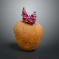 Orange root vegetable with purple red sprouts on top placed on smooth gray surface