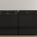 Sleek Black Kitchen Appliances Placed Side By Side Against Light Colored Wall And Wooden Floor