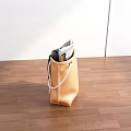 Brown Storage Bag With White Handles Holding Gray Scarf And Magazines On Wooden Floor