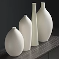 Four White Vases Arranged On Black Metal Frame Table Against Dark Gray Wall