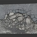 Damaged Asphalt Road Ground with Visible Cracks and Scattered Broken Stones