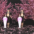 Two Female Figures With Purple V Stands Among Pink Cherry Blossom Trees And Scattered Petals