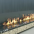 Modern Fireplace With Black Wood Panel And Burning Flames On Marble Hearth And Patterned Cabinets