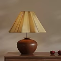 Brown Wooden Table Lamp With Beige Pleated Shade On Wooden Desk And Red Decor
