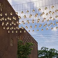 Warm Hanging Decorative Lights Illuminate Outdoor Building Space With Trees At Dusk