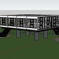 Modern Elevated Building With Glass Windows And Pillars On Green Lawn