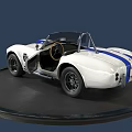 White Convertible Sports Car With Blue Racing Stripes On Black Circular Display Platform