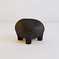 Black Stuffed Animal Toy with Textured Surface and Four Short Legs on White Background