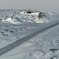Vast Snow Covered Scenic Landscape With Stretching Road And Distant Rocks