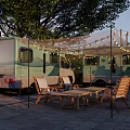 Evening RV Camping Scene With String Lights Outdoor Table Chairs And Trees