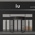 Modern Hotel Entrance With Revolving Glass Door And Black Facade IU Signage