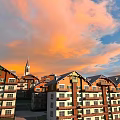 Residential Building Complex With Red Brick White Walls Featuring Spire Under Orange Sunset Sky Clouds