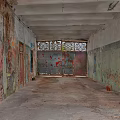 Abandoned Corridor Featuring Peeling Walls Worn Iron Door Flaking Paint And Concrete Floor