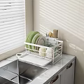 Dinnerware Set in White Rack with Green White Plates Glass Cups on Marble Kitchen Countertop