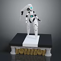 White Robot Character Standing On Black Base With Golden KORBOTRON Letters