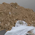Stone And Wood Construction Materials Pile With Dirt And White Cloth Cover