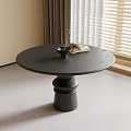 Black Round Dining Table in Modern Interior with Vase Plant and Open Book