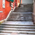 Historic Stone Stairs In Urban Alleyway With Red Brick Wall And Street Sign