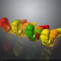 Colorful Gummy Worms With Red Yellow Green Smiley Face Shapes On Black Surface