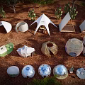 Unique Campsite With Various Shaped Tents Surrounded By Trees And Red Cliffs At Dusk
