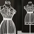 White Mannequins With Intricate Decorative Design Standing Against Black Background