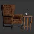 Brown Tufted Armchair With Wooden Legs And Small Round Table Featuring Teapot Teacup