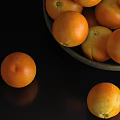 Fresh Oranges In A Bowl And Scattered On Black Background