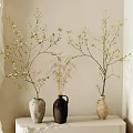 Gray Black and Beige Ceramic Vases with Blossom Branches on White Pedestal Against Neutral Wall