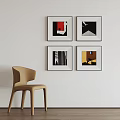 Four Abstract Paintings on White Wall with Beige Chair in Room