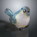 Decorative Bird Figurine With Blue Yellow White Feathers Standing On Smooth Surface Against Gray Background