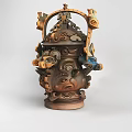 Intricately Carved Ceramic Vessel With Multiple Animal Faces And Brown Blue Tones