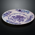 Traditional Blue and White Ceramic Plate Decoration with Intricate Floral Fruit Patterns Against Dark Background
