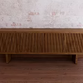 Wooden TV Cabinet With Vertical Slats Against Textured Wall And Wooden Floor