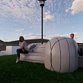 Airplane Shaped Public Chair On Green Lawn With People Sitting And Potted Plants