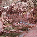 Tranquil Garden Landscape Featuring Rock Formations Small Waterfall Flowing Stream And Green Plants