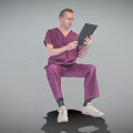 Professional Man in Purple Medical Scrubs Sitting Using Digital Tablet