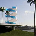 Outdoor Blue Spiral Staircase Design With Palm Trees Near Waterfront Grass Area