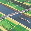 Scenic Bridge Over River With Cargo Ship Green Farmland And Trees