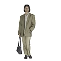 Woman in Plaid Blazer White Shirt Beige Pants Holding Gray Handbag Standing Against Gray Background