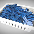 White Plastic Basket Filled With Blue Clothespins For Household Use