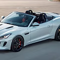 White Jaguar Convertible Driving On Open Road With Sporty Design Black Wheels And Red Interior